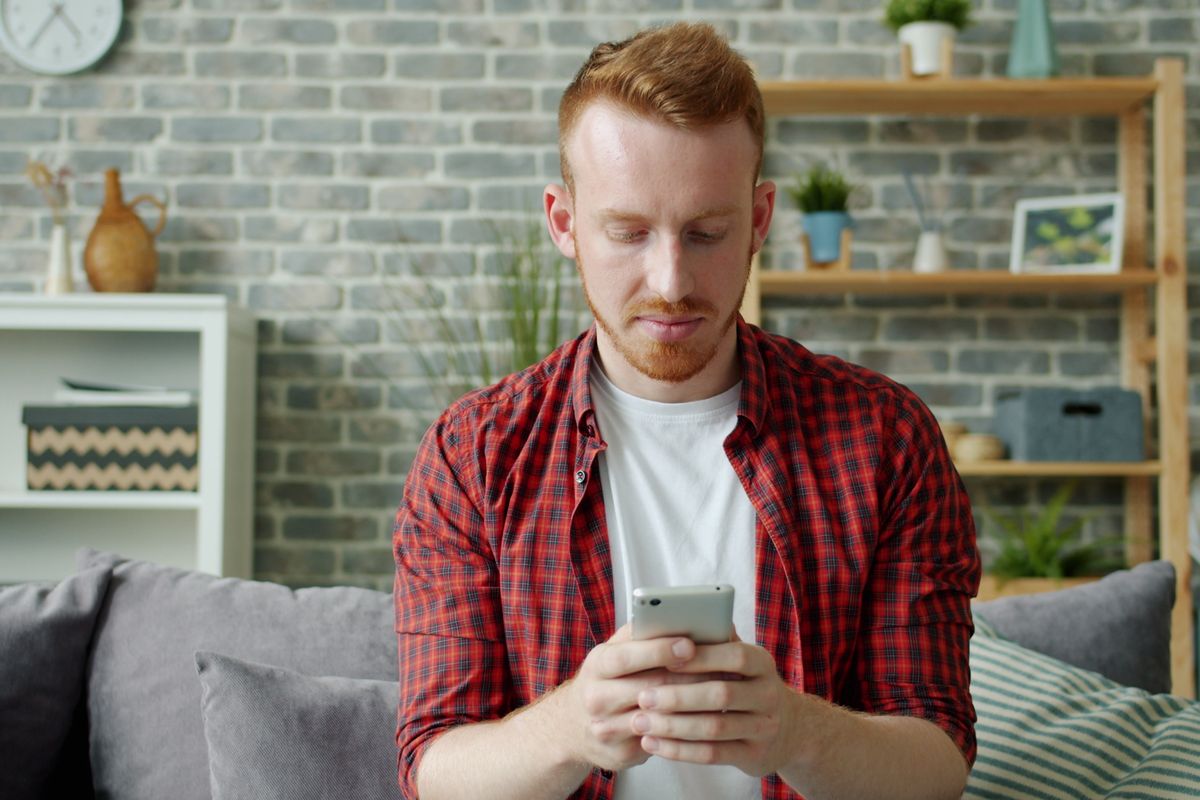 Person messaging on a smartphone at home